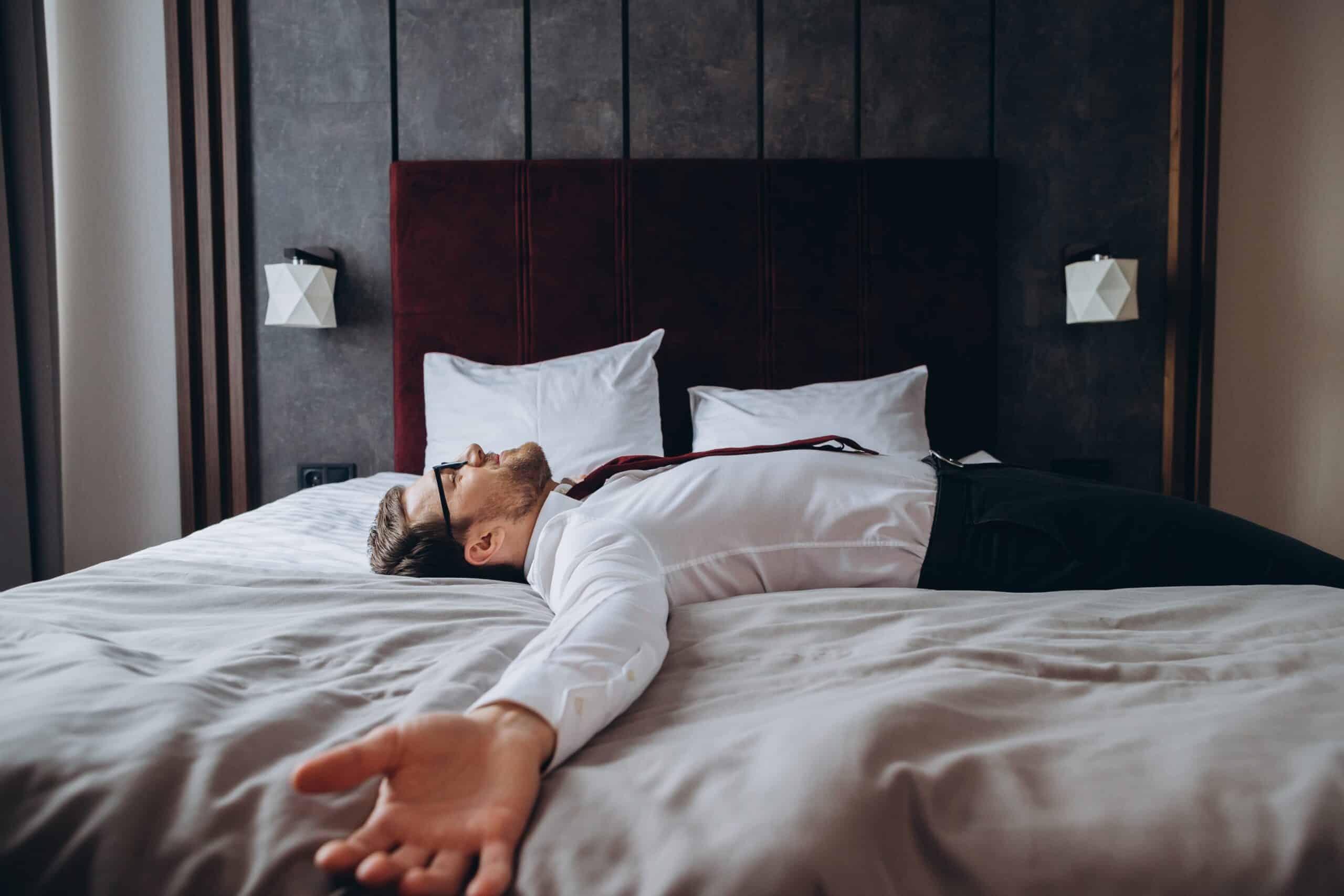 A man lying on a hotel bed