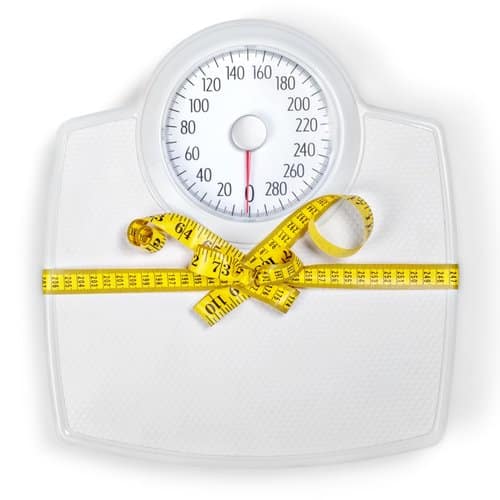A photo of a scale with a tape measure bow tied around it